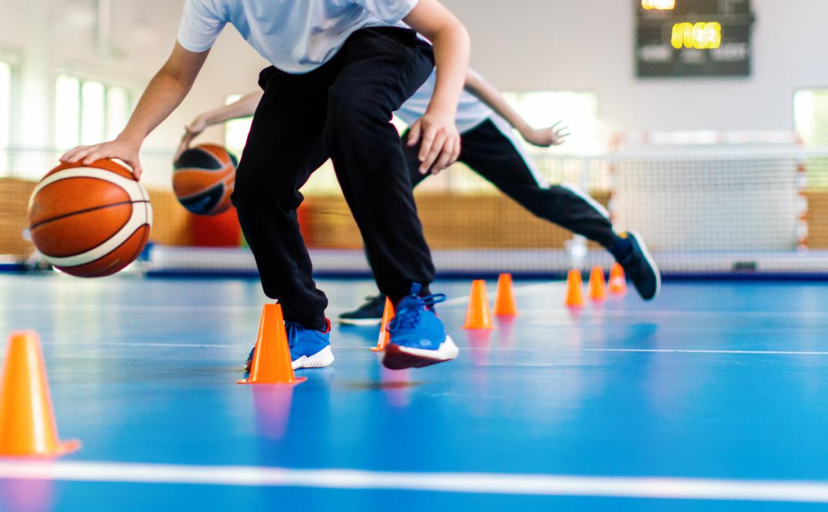 Jongens die basketbal spelen in gymzaal