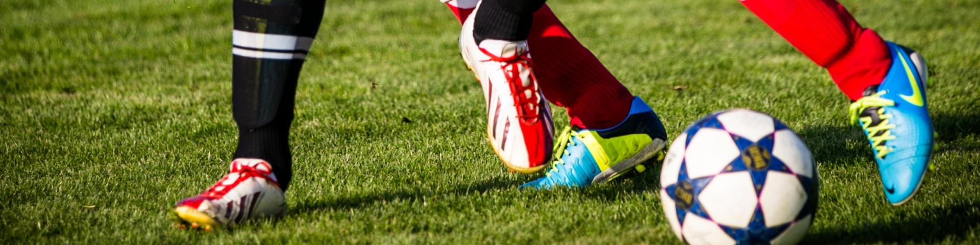 Twee voetballers met bal op gras